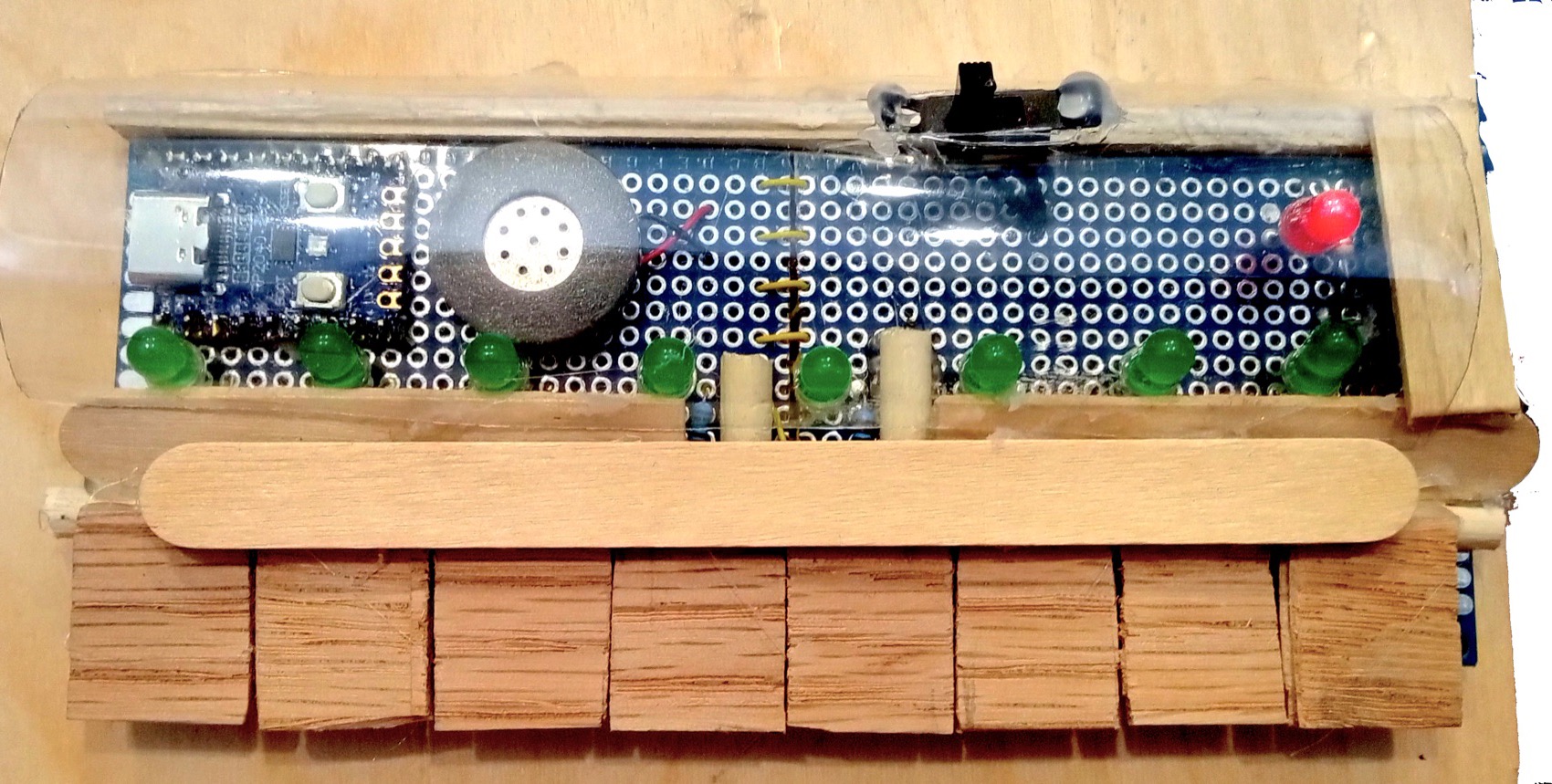 A handmade electronic piano project with LEDs and wooden keys.